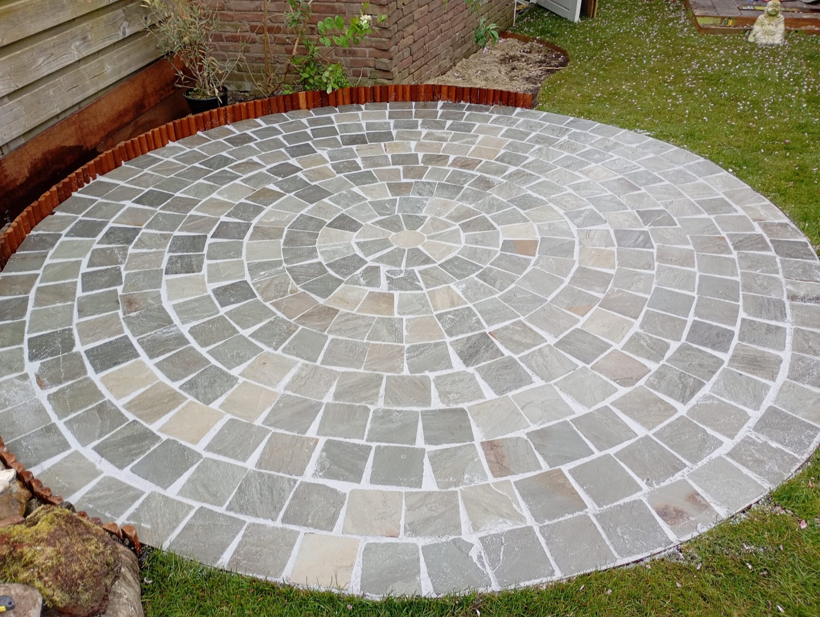 Rond natuurstenen terras met sierpatroon